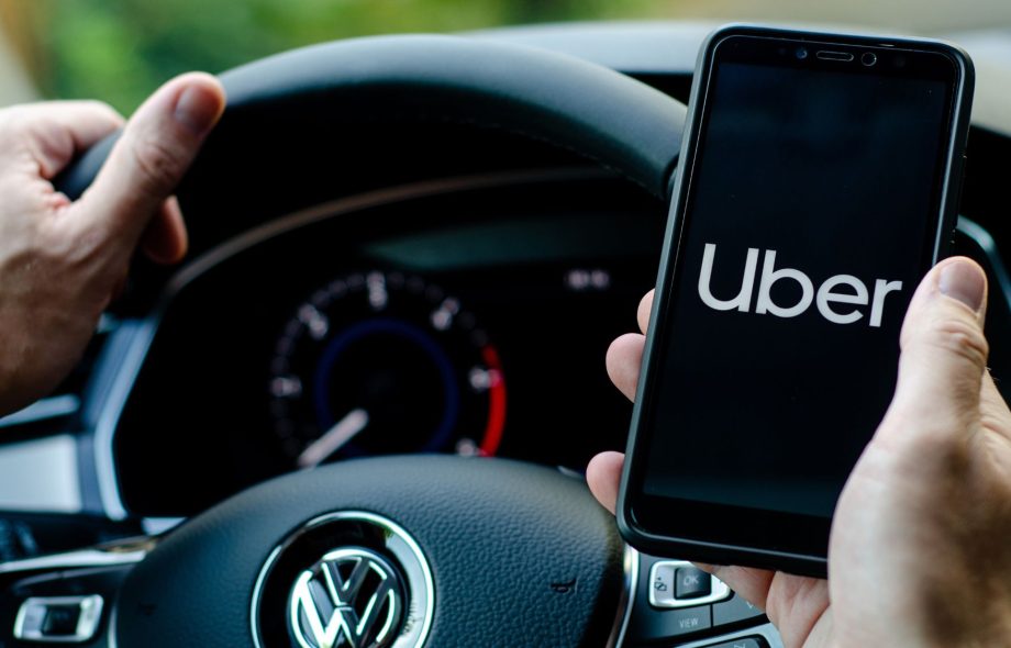 A man holding a phone showcasing Uber claims