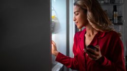 A woman opened up a freezer, checking the efficiency of a refrigerator