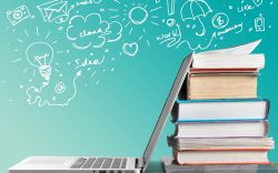 Stack of books with laptop on table